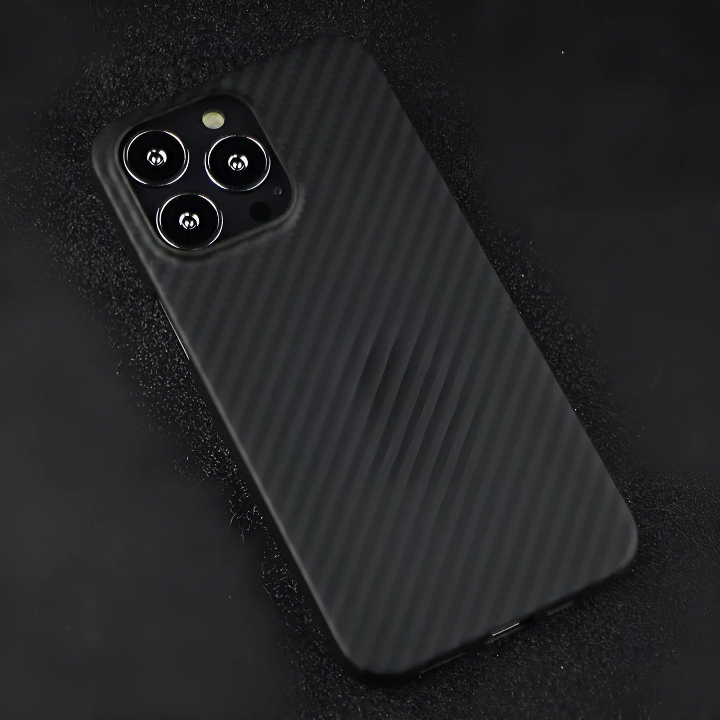 Dull black Kevlar fibre iPhone case with a stripe design on the back, shown on an iPhone model.