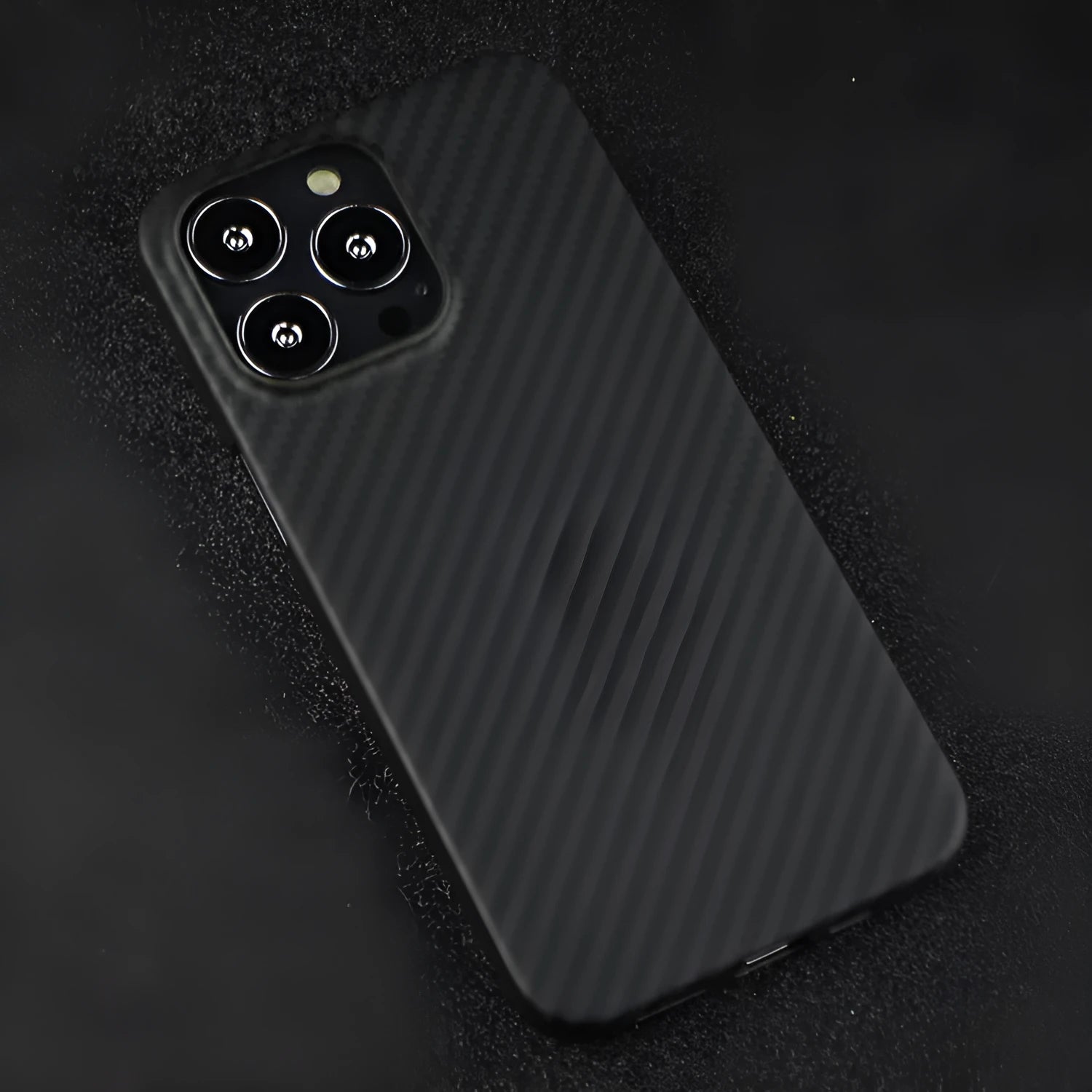 Dull black Kevlar fibre iPhone case with a stripe design on the back, shown on an iPhone model.