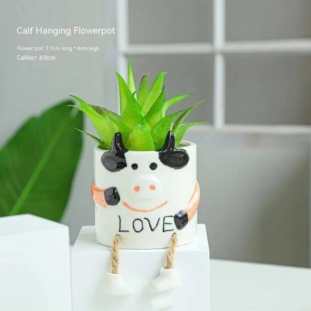 Ceramic hanging foot flowerpot for succulent plants with cartoon styling on desktop