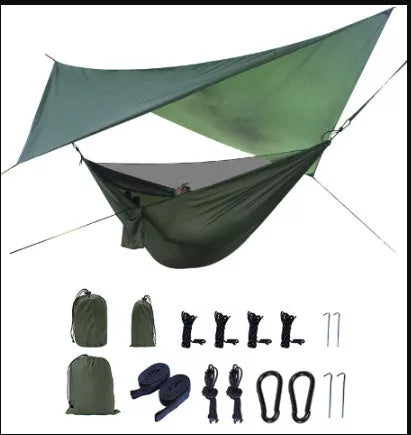 Portable camping hammock with mosquito net and awning setup in a forest