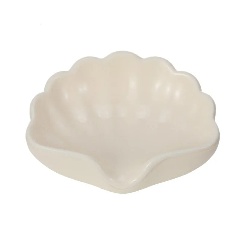 Plastic shell soap dish in pearl white, dimensions 12x9x5.5cm, on a bathroom counter