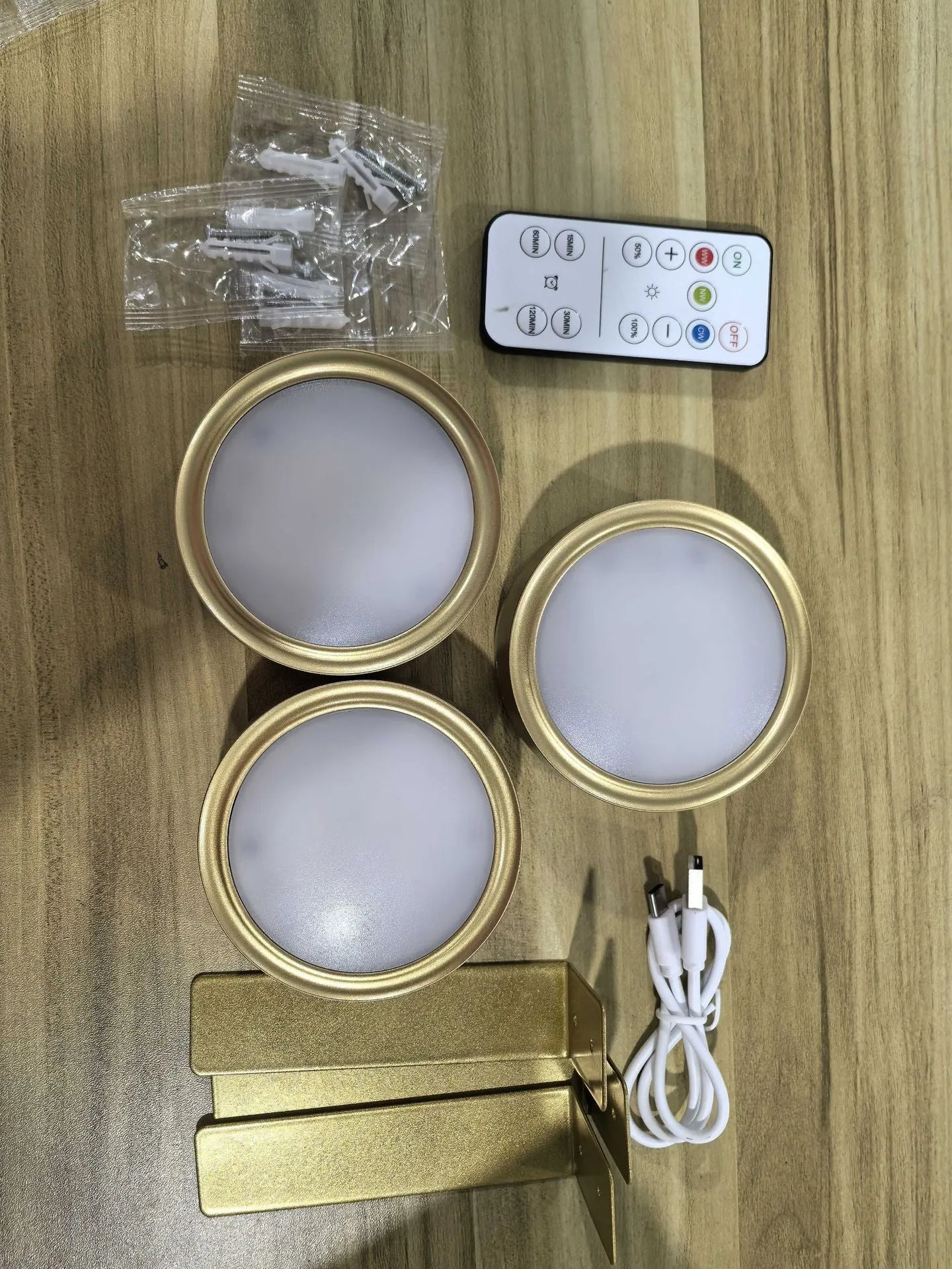 Black magnetic LED painting lamp with remote control on a white wall.