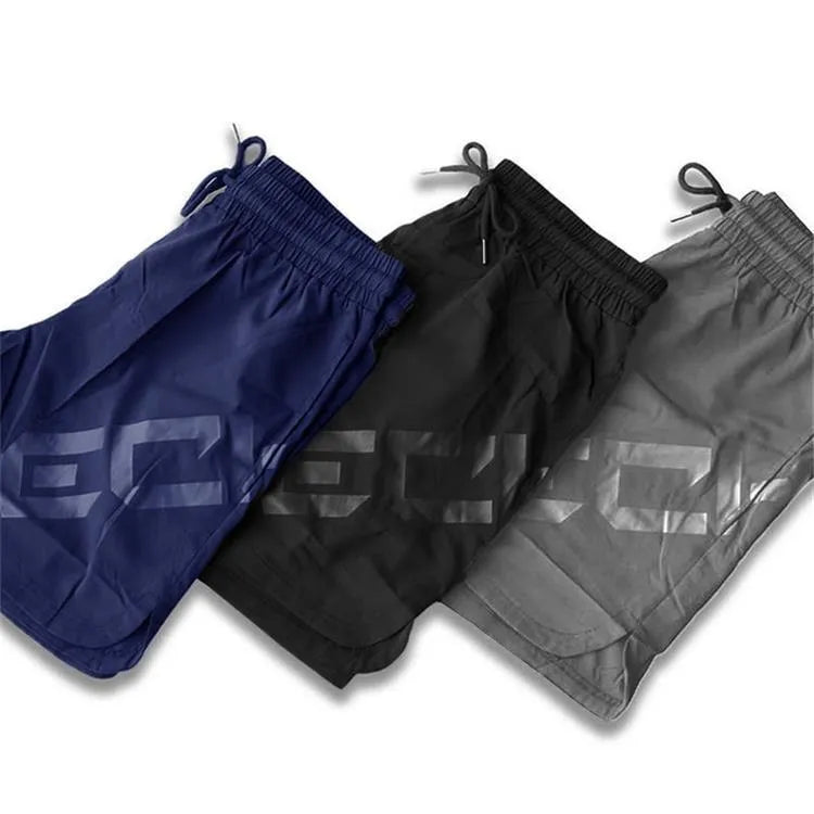 Men's black quick-dry training shorts with elastic waistband, shown knee-length.