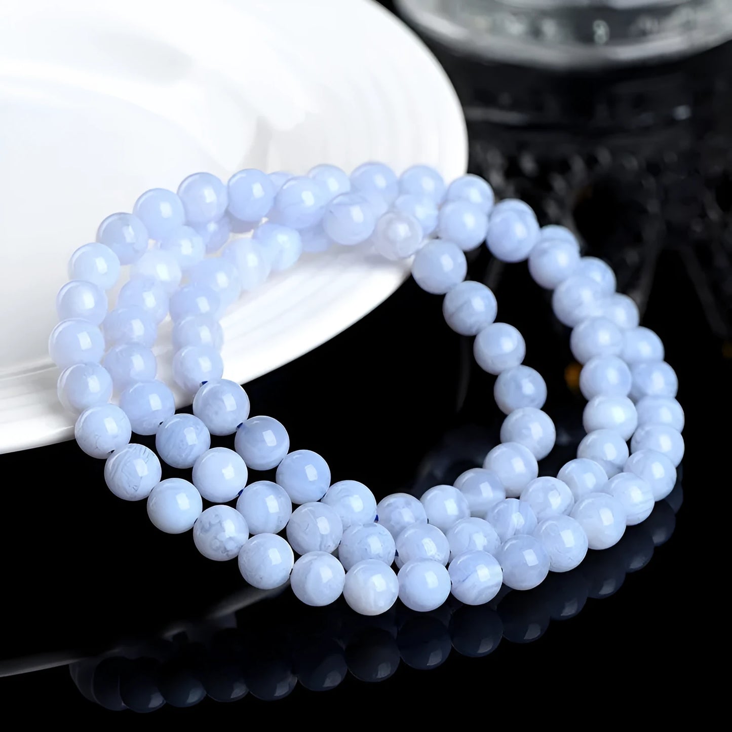 Blue agate bracelet with 6-6.8mm beads in multi-circle pattern and Ruyi elements on a wrist.