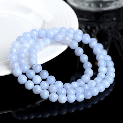 Blue agate bracelet with 6-6.8mm beads in multi-circle pattern and Ruyi elements on a wrist.