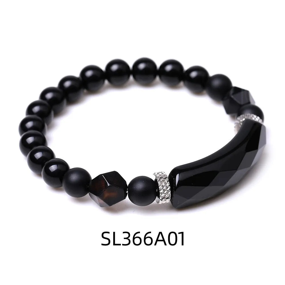 Handmade diamond-shaped cut black agate bracelet with fan-shaped details on a wrist.