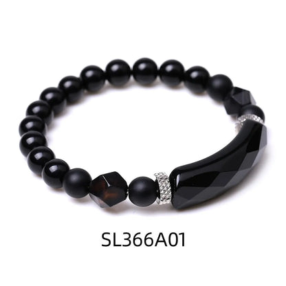 Handmade diamond-shaped cut black agate bracelet with fan-shaped details on a wrist.