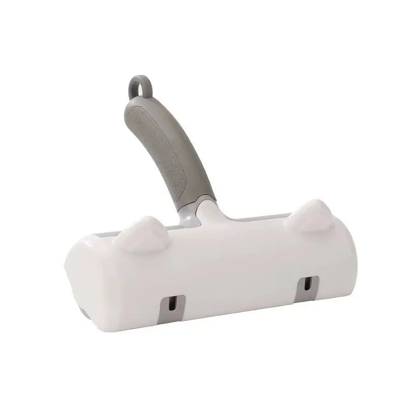 Mint green plastic cat hair removal brush with an ear-style handle on a fabric sofa.
