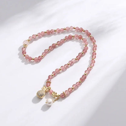 Women's geometric strawberry quartz crystal bracelet with a silver wallet money charm.