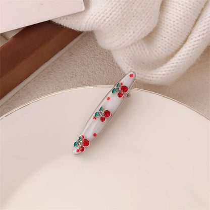 Red plastic hair clip with a 3D love heart and dots on a willow leaf-shaped base.