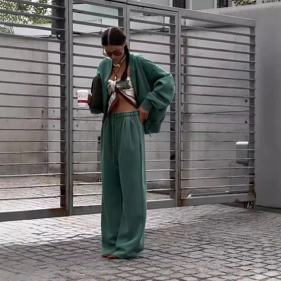 Green women's thermal sweater with front zipper and stand collar, paired with matching trousers