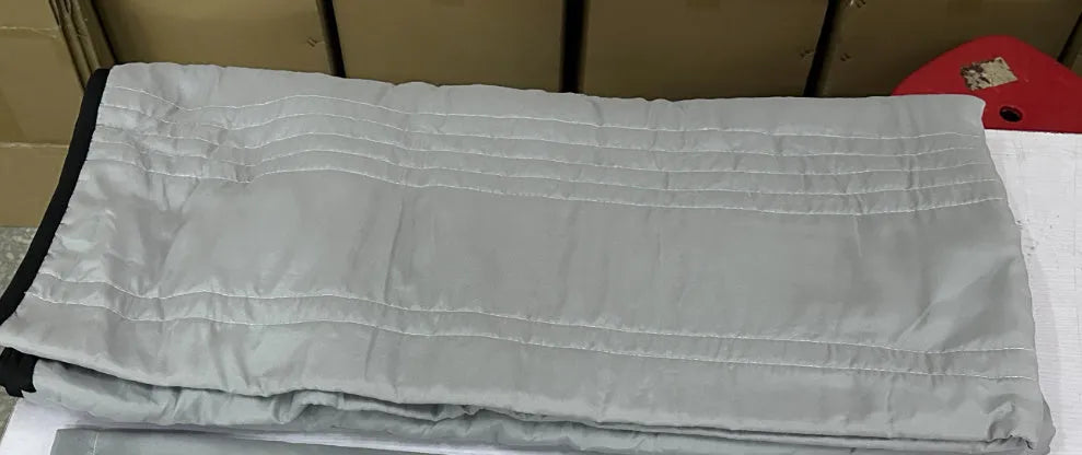 Lightweight plain coloured polyester summer quilt on a bed