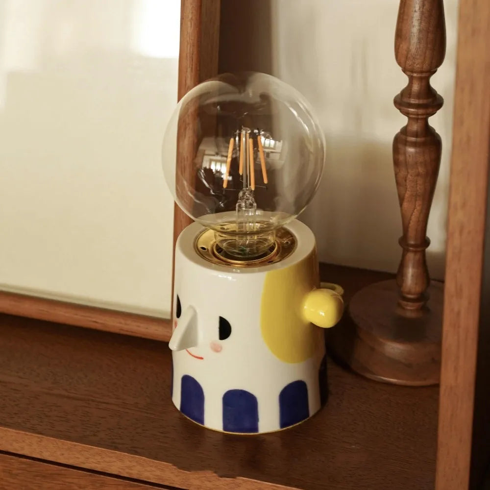 Handmade ceramic lamp with ball headlight design on a bedside table