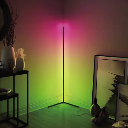Black smart RGB floor lamp with remote control showing colour-changing illumination in bedroom setting
