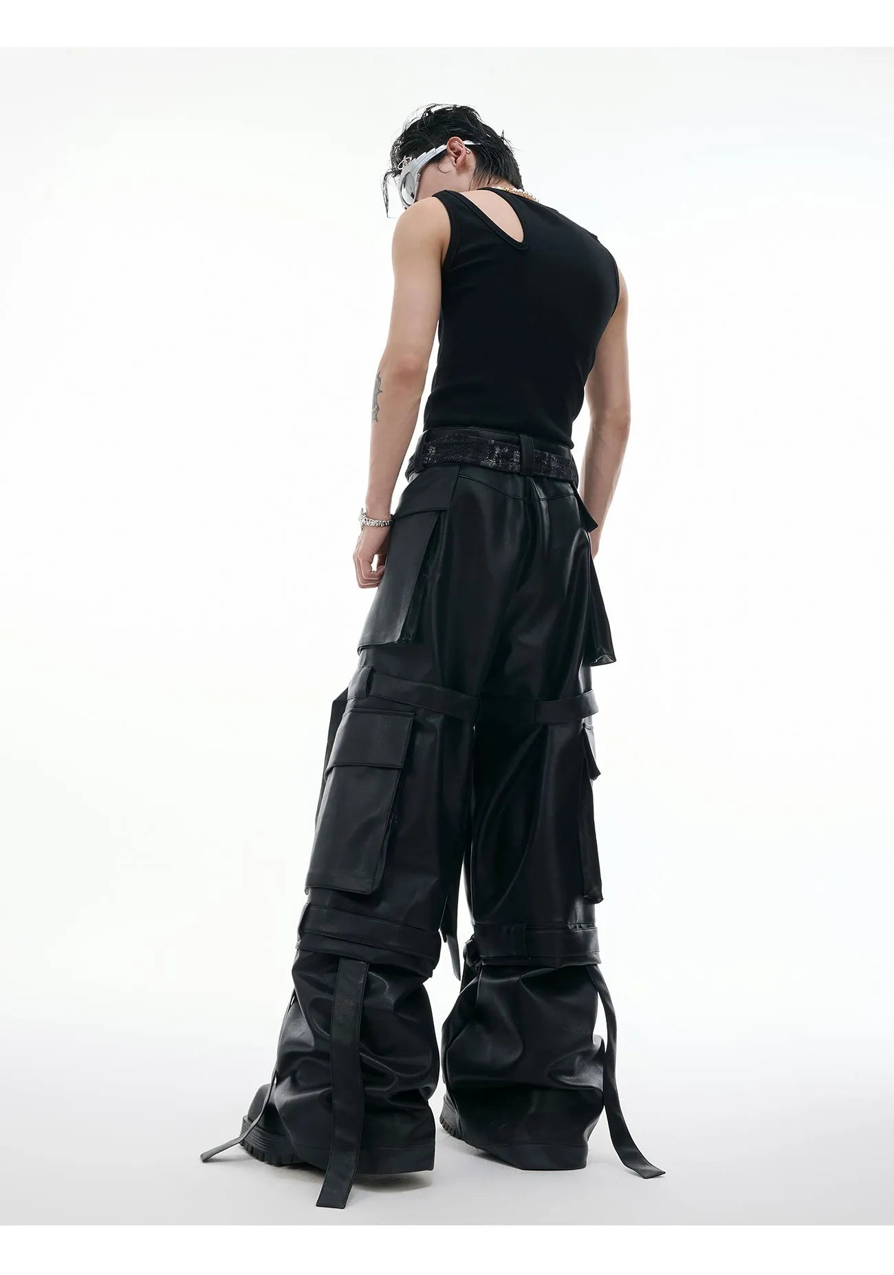 Black loose-fit trousers with quilted texture, multiple pockets, and stitching ribbon leather accents on model