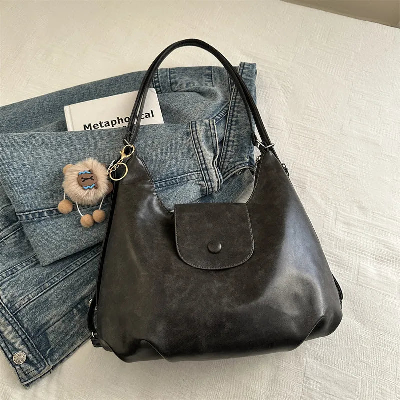Textured PU leather women's shoulder bag in black with single strap and optional pendant