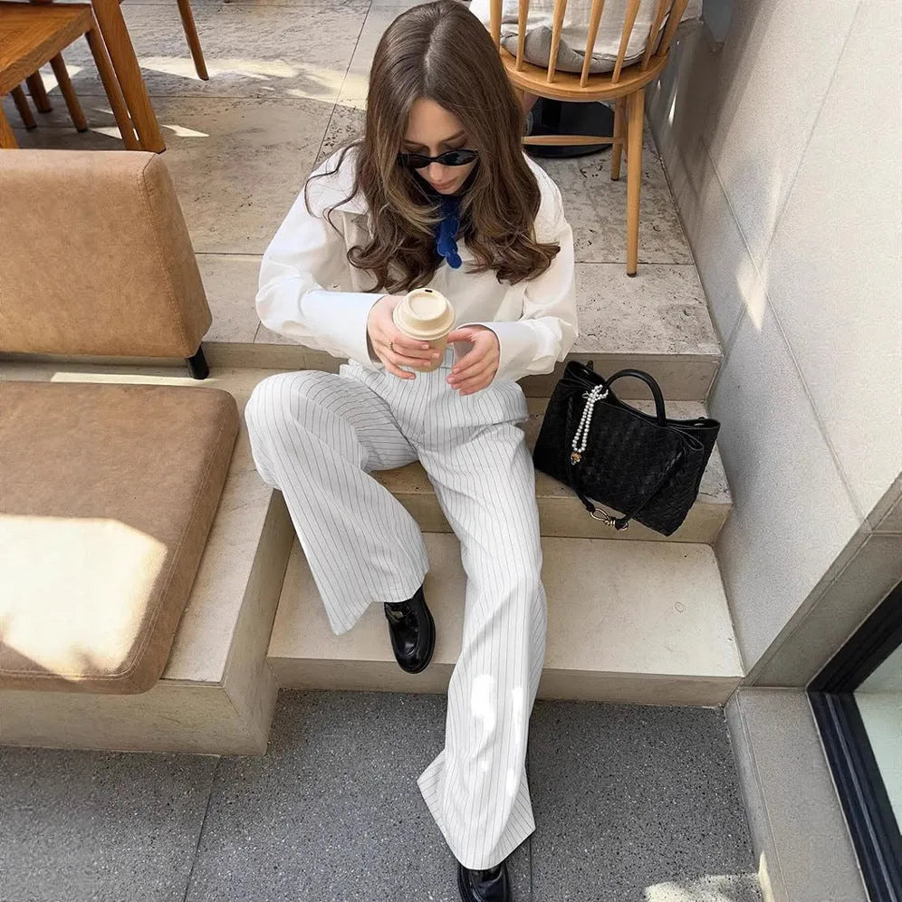 White striped wide-leg casual trousers with a front zipper on a hanger.