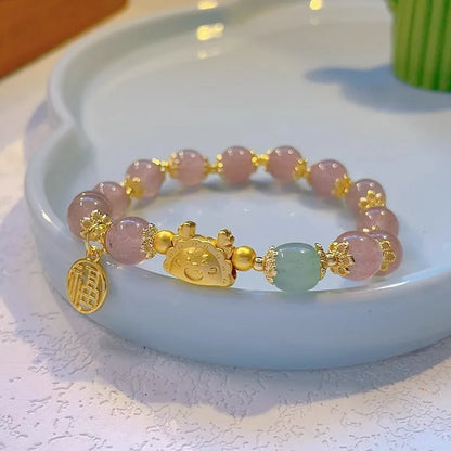 A women's glass glazed bracelet with floral and zodiac animal charms in red, pink, and white pearl beads.