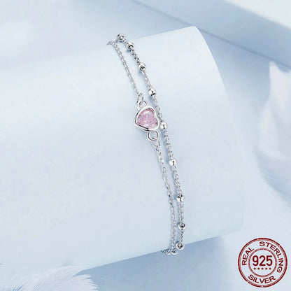 Close-up of a sweet girlish style 925 sterling silver bracelet with a small heart-shaped pendant on an adjustable chain.