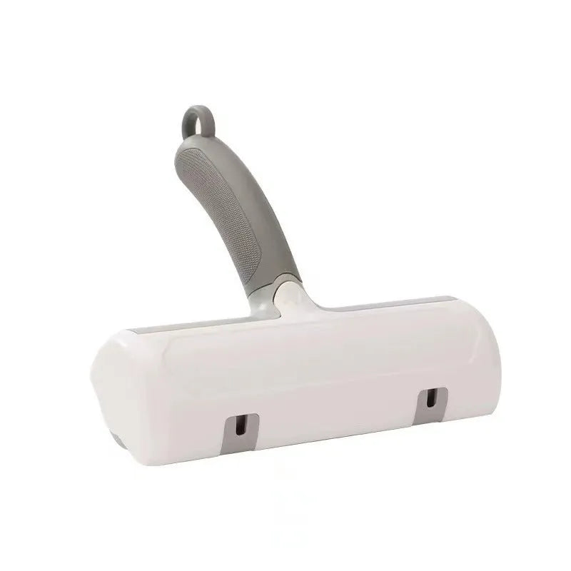 Mint green plastic cat hair removal brush with an ear-style handle on a fabric sofa.