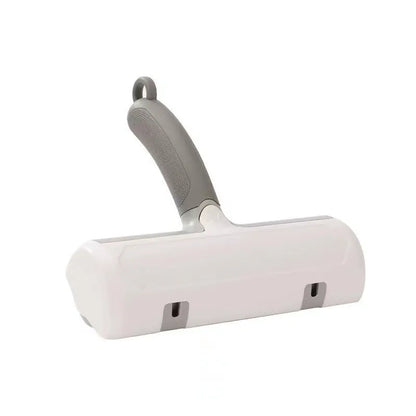 Mint green plastic cat hair removal brush with an ear-style handle on a fabric sofa.