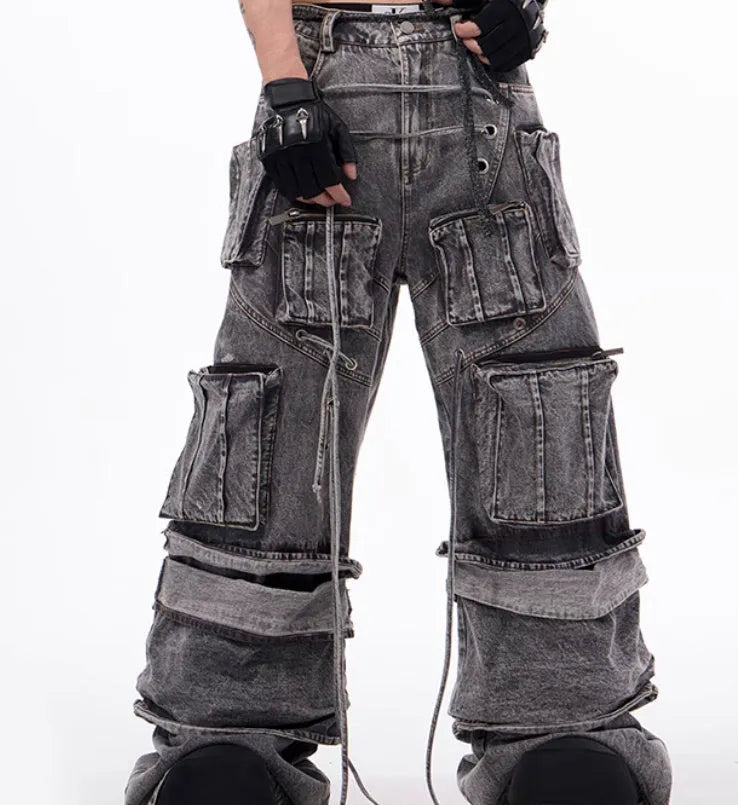 Grey distressed denim overalls with rope stitching on a man, showcasing the mop pant style.