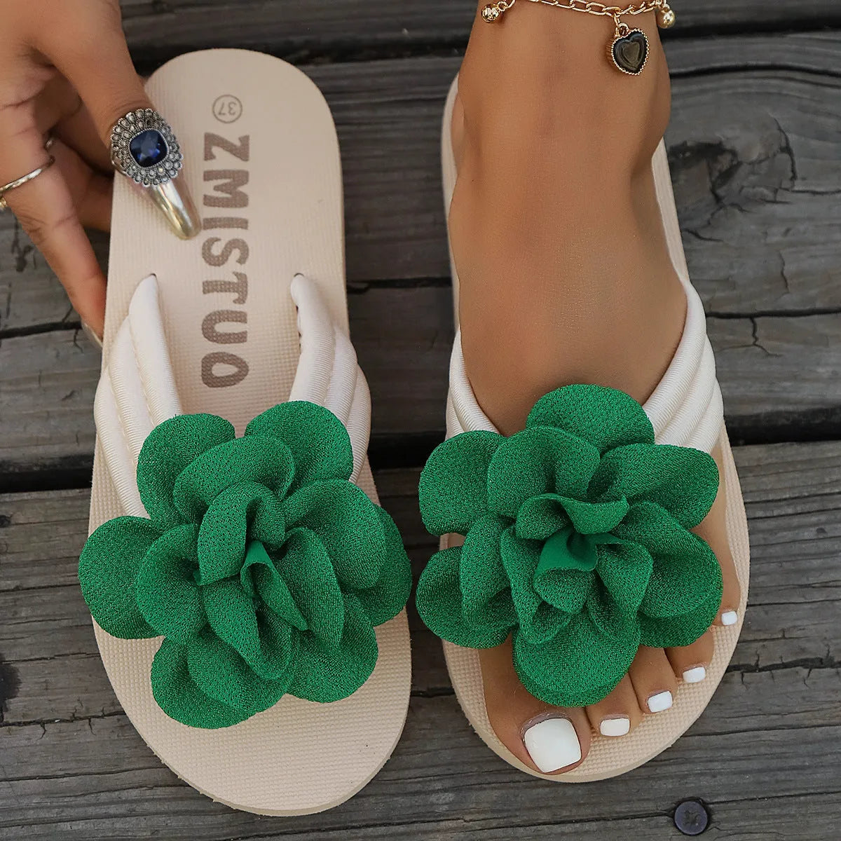 Women's plus size green PU flip flop slippers with flower pattern on a white background.