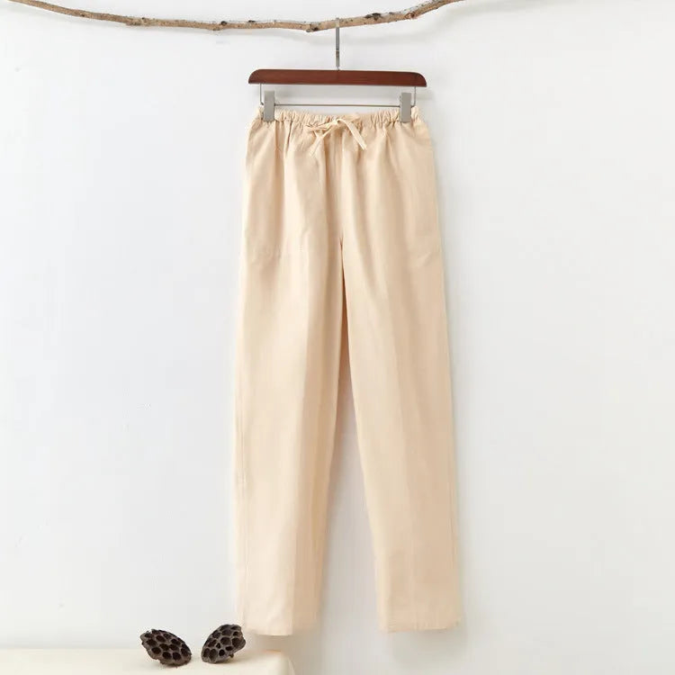 Men's beige pure cotton casual trousers with a drawstring waist on a mid-grey background.