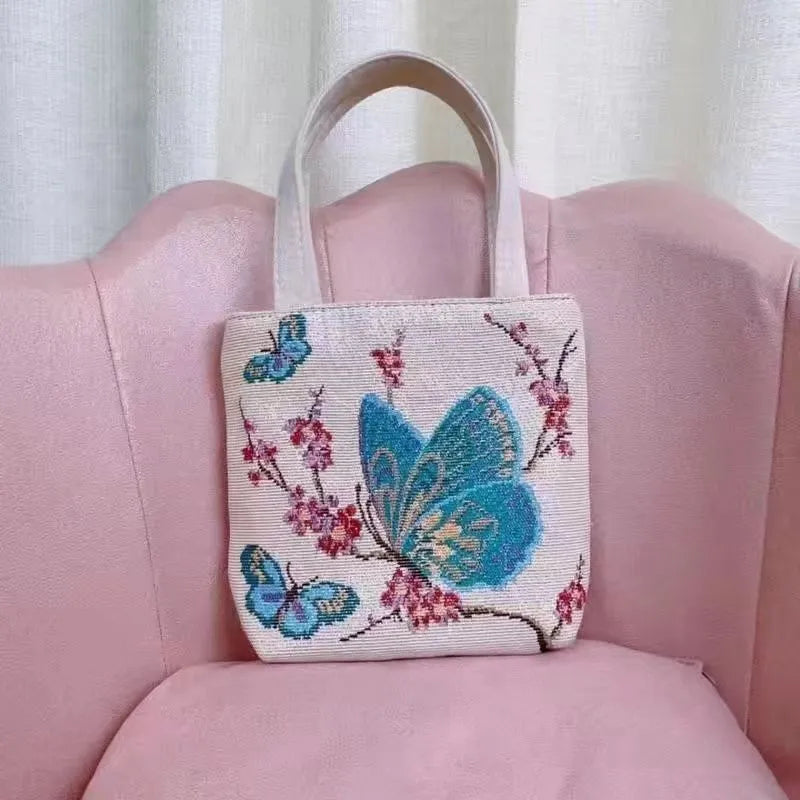 Colourful embroidered canvas shoulder bag with gold wire handles shown in small, medium, and large sizes.