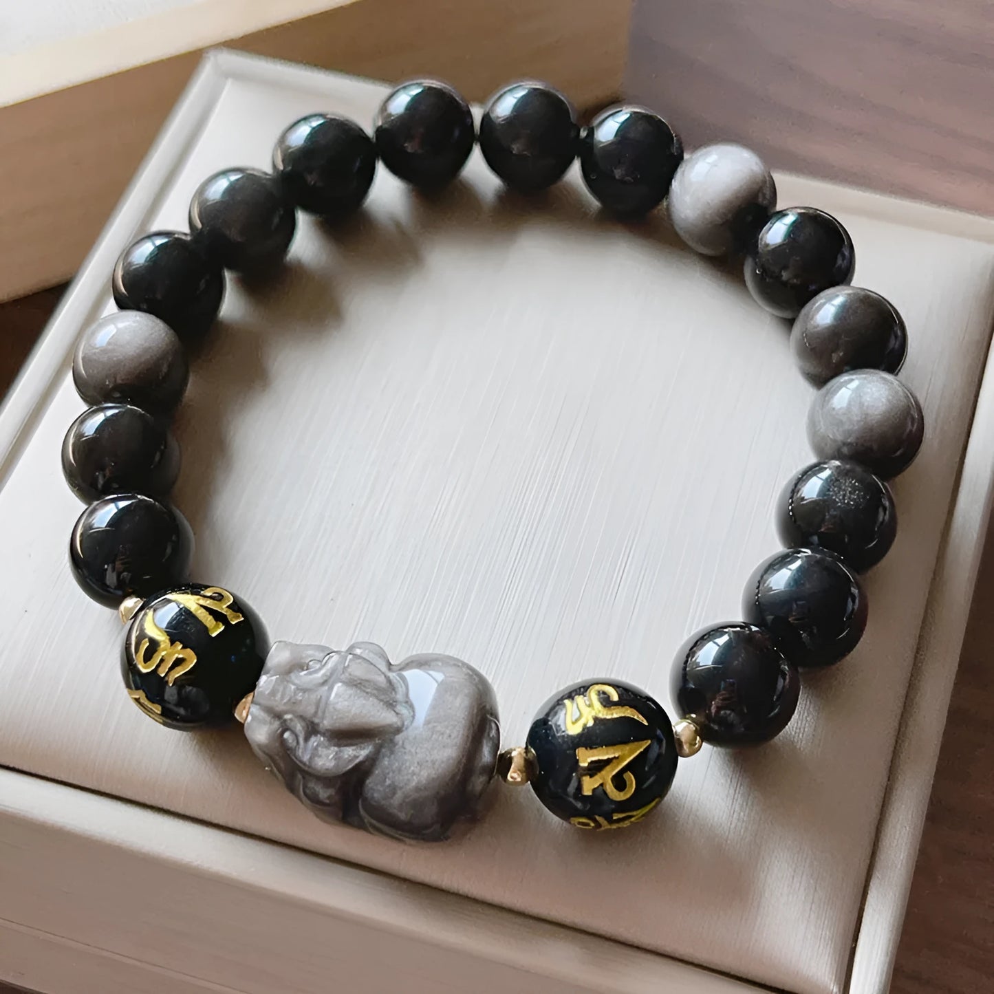 Men's silver stone bracelet with engraved proverb beads and Chinese zodiac style on a wrist.