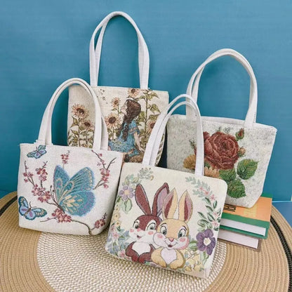 Colourful embroidered canvas shoulder bag with gold wire handles shown in small, medium, and large sizes.
