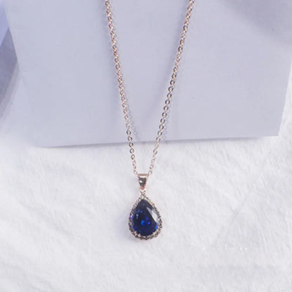 Rose gold geometric water drop pendant necklace on a model, showing adjustable chain and sparkling stone inlay.