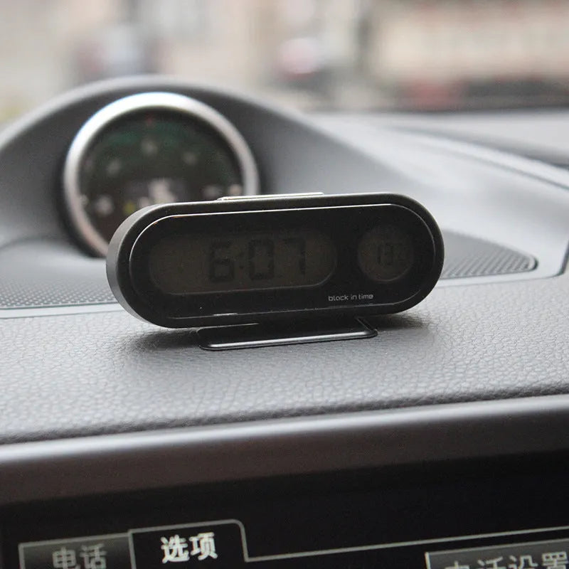 Black electronic car clock thermometer with LED display showing time and temperature, mounted on adjustable bracket