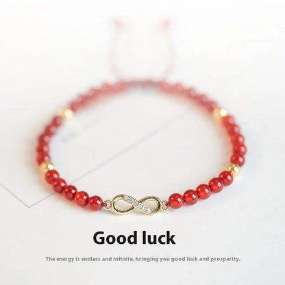 Hand-woven red agate beads bracelet with lucky charm in ethnic style, showing diamond-shaped beads.