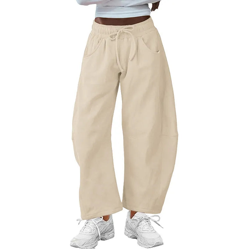 Loose-fit cropped sweatpants in army green with a drawstring waistband and side pockets on a neutral background