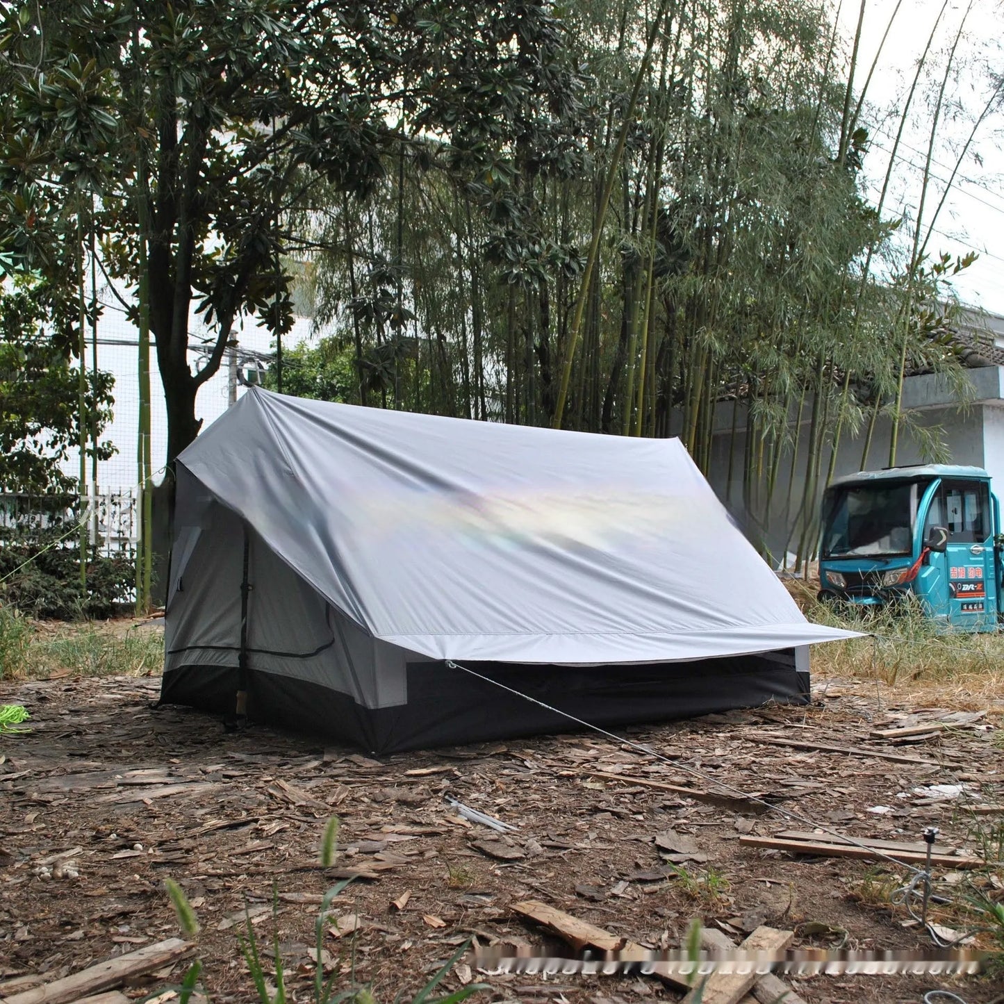 Brown and white portable A-line camping tent set up with hiking poles, showing its spacious interior for 2-3 people.