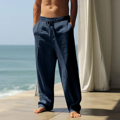 Man wearing loose-fit solid colour cotton casual trousers in grey, showing the relaxed fit and simple design.