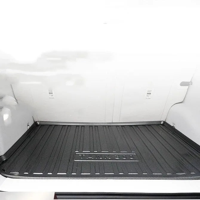 Black car boot liner with carbon fibre pattern texture, lying flat as a protective tailgate mat.