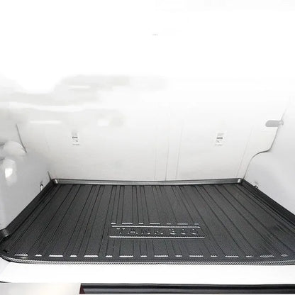 Black carbon fibre pattern TPE boot liner moulded to fit a car luggage bay, showing textured anti-slip surface.