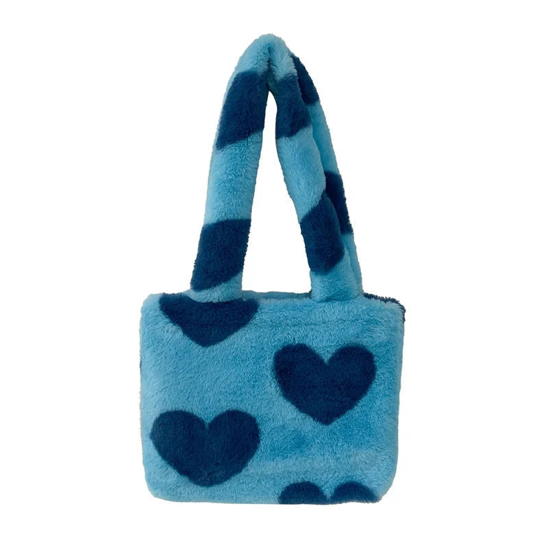 Soft, plush heart-shaped handbag in various vibrant colors with a magnetic closure and interior phone compartment