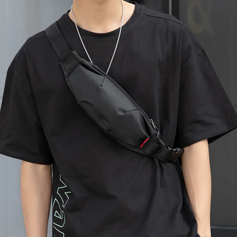 Black Oxford cloth waist pack measuring 12cm high by 27cm wide with crossbody strap and zipper closure