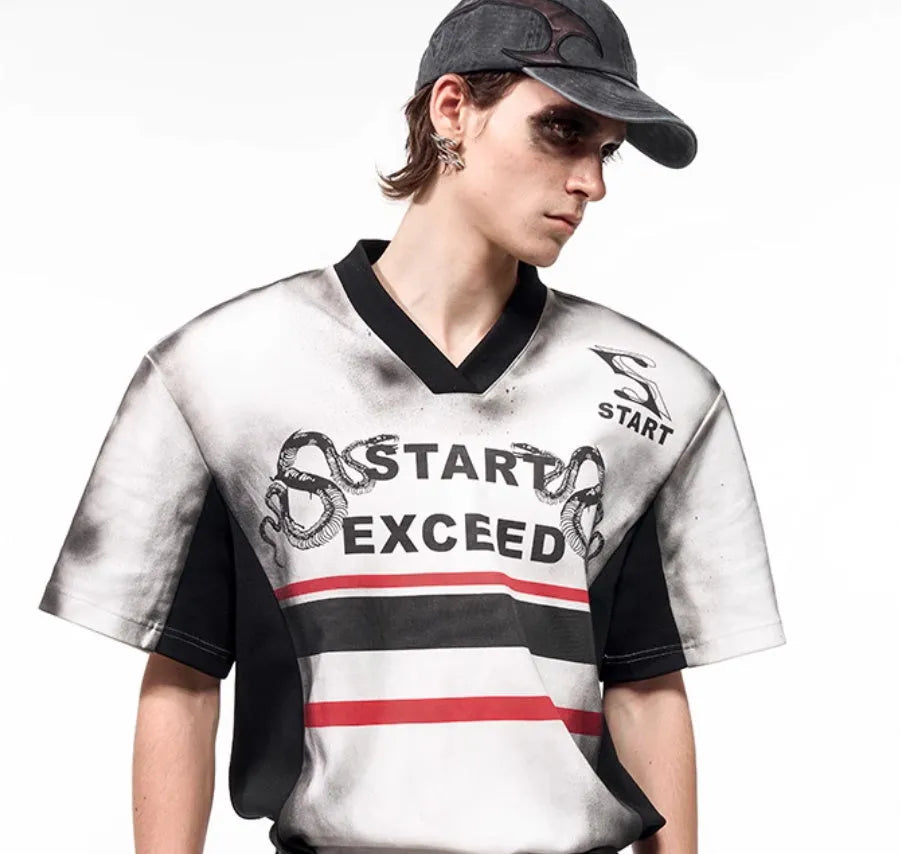 Women's V-neck short sleeve top with padded shoulders and a grey letter snake pattern print.