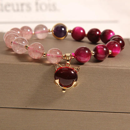 Simple women's bracelet with a red strawberry crystal charm on a black elastic rope.