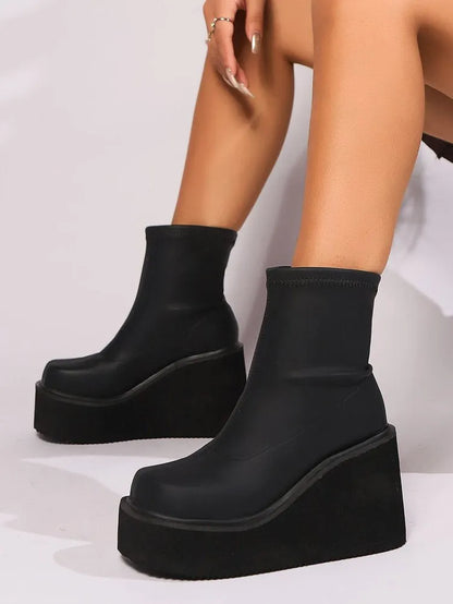 Plus size women's black wedge heel boots with round toe and waterproof platform sole.