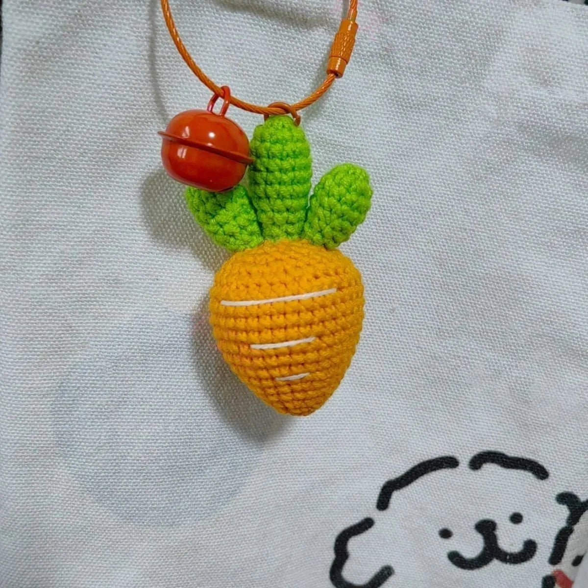 Cartoon carrot car design wool felt keychain pendant on a keyring.
