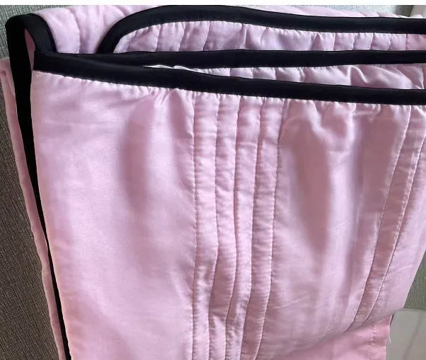 Lightweight plain coloured polyester summer quilt on a bed