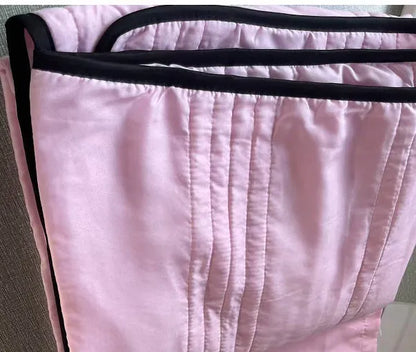 Lightweight plain coloured polyester summer quilt on a bed