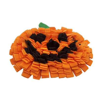 Orange pumpkin-shaped fleece pet slow feeder mat for dogs and cats on a wooden floor