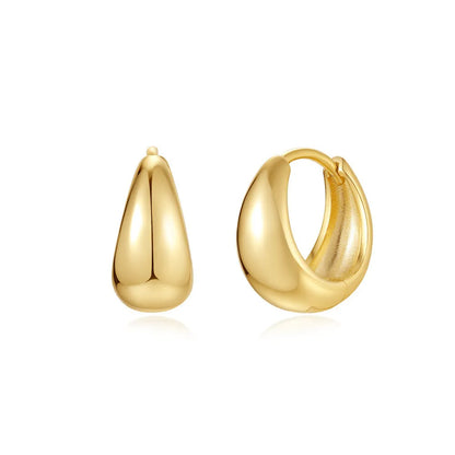 A pair of golden geometric clip-on earrings with a round design element on a white background.