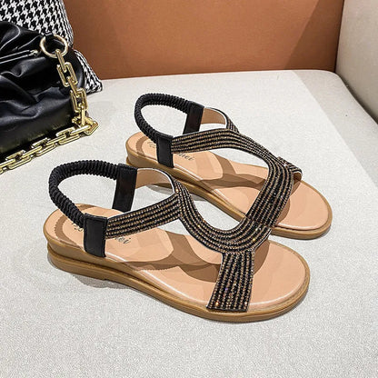 Gold patent leather women's sandals with rhinestone decoration on the strap.